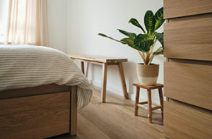 Wood-like light oak looking laminate flooring in a small bedroom